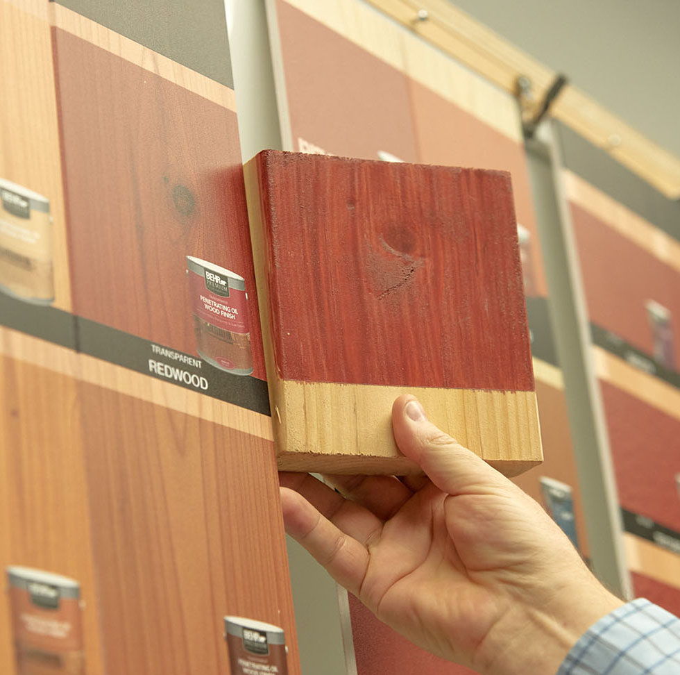 A Bernard Group employee color matches wood stain to print.