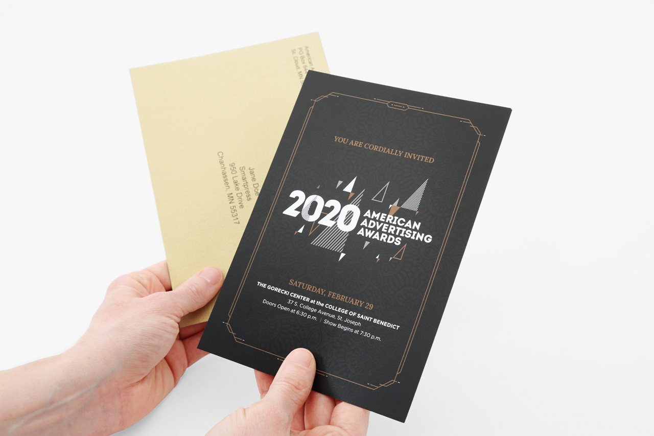 Two hands holding a custom invite and envelope.