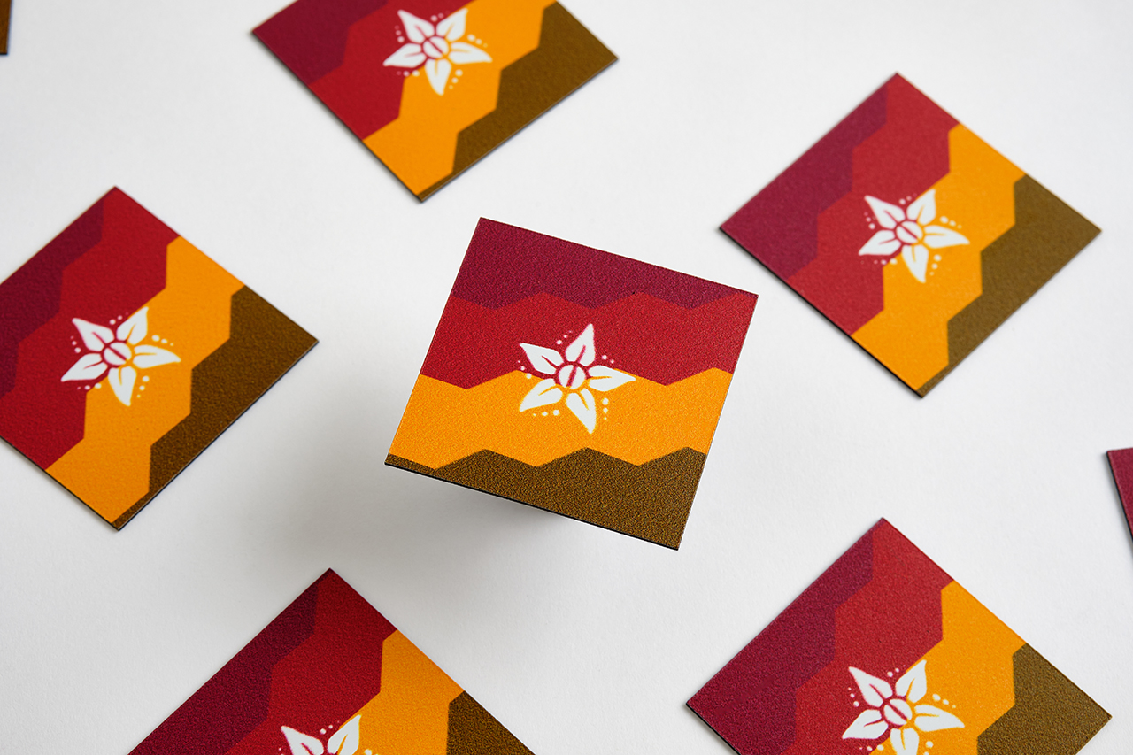 Custom die-cut magnets printed with a red, yellow and brown design and a white star in the middle.