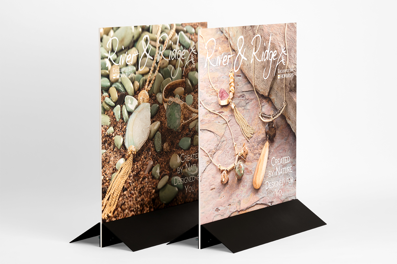 Two free-standing signs designed with jewelry marketing and secured in black bases.