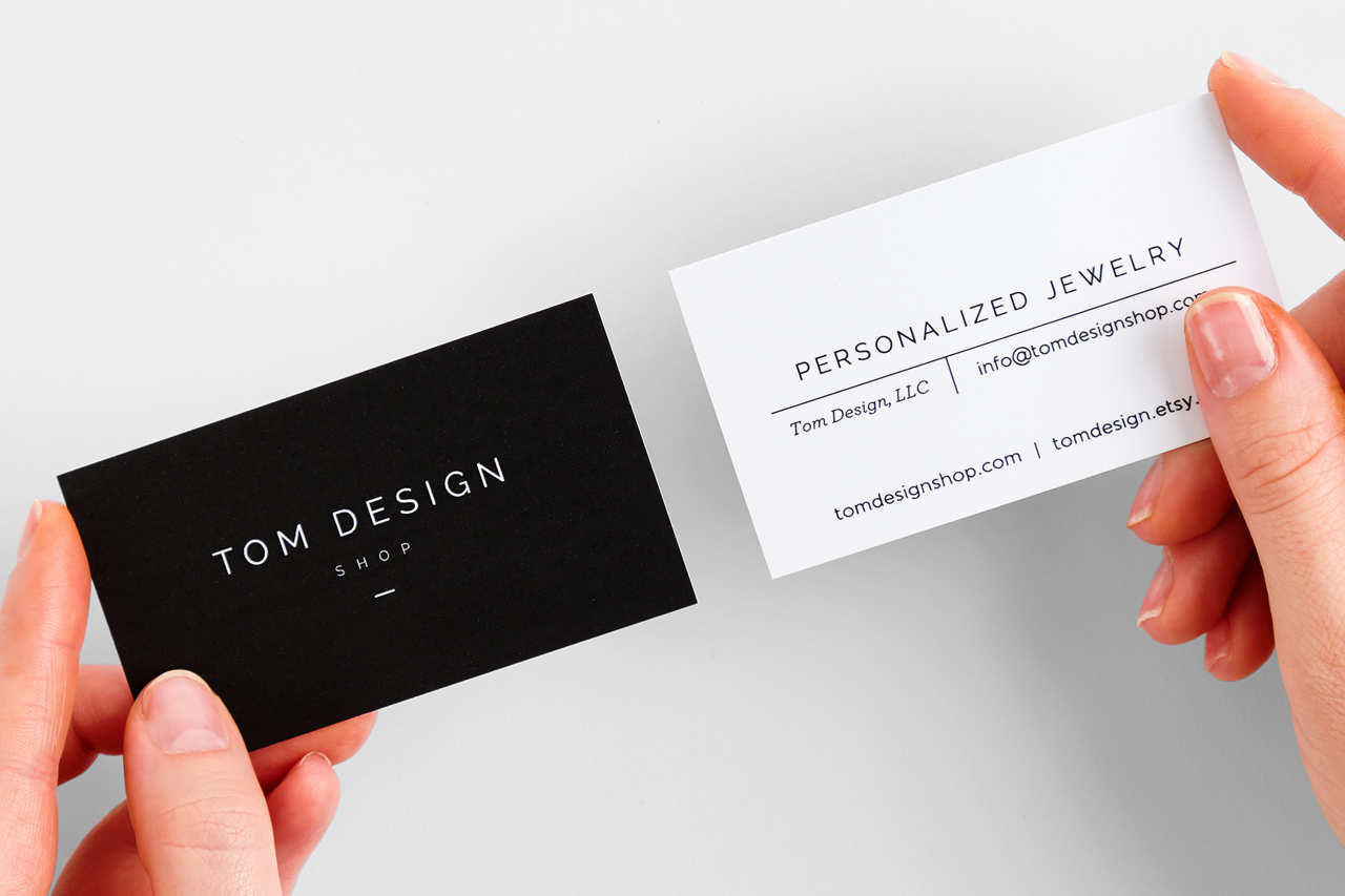 Two hands holding two custom business cards with 