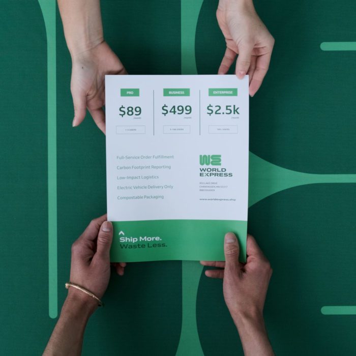 Four hands holding a custom sell sheet printed with a green and white design and pricing details.