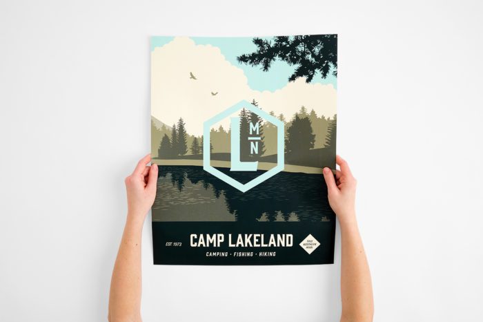 Two hands holding a wall decal printed with "Camp Lakeland."