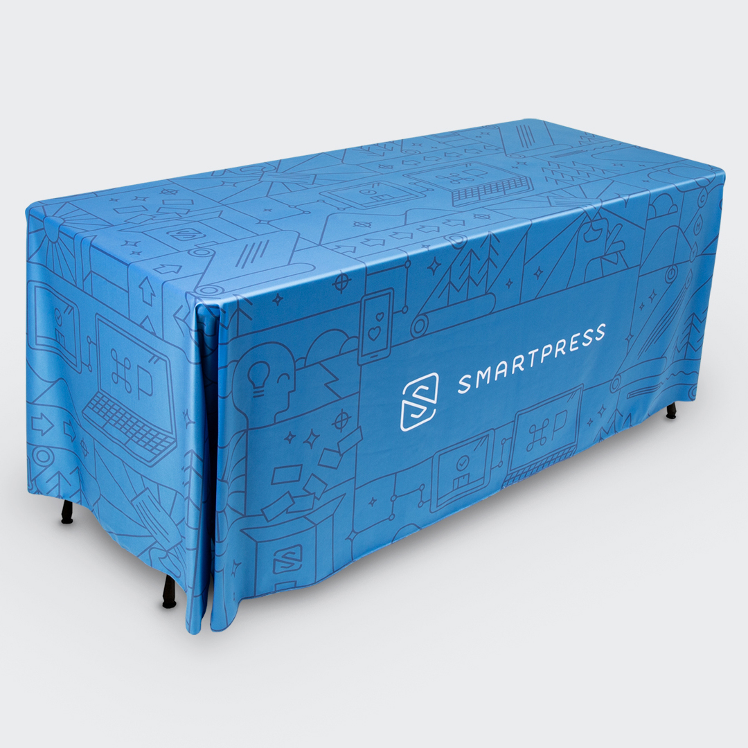 A table throw draped over a table and printed with a blue background, black illustrations and Smartpress in white.