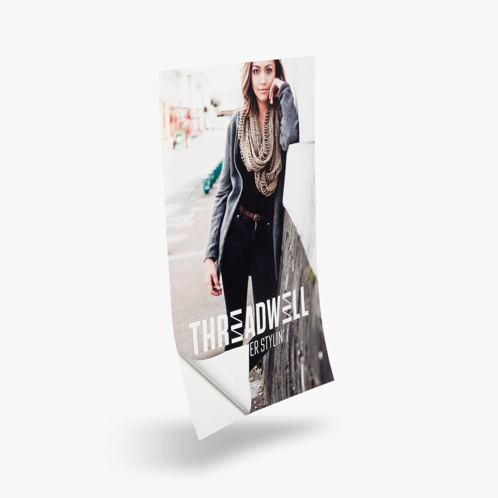 A window and wall decal for threadwell. The decal includes a woman leaning against the wall. The corner edge is lifted up to show the peel-off feature.