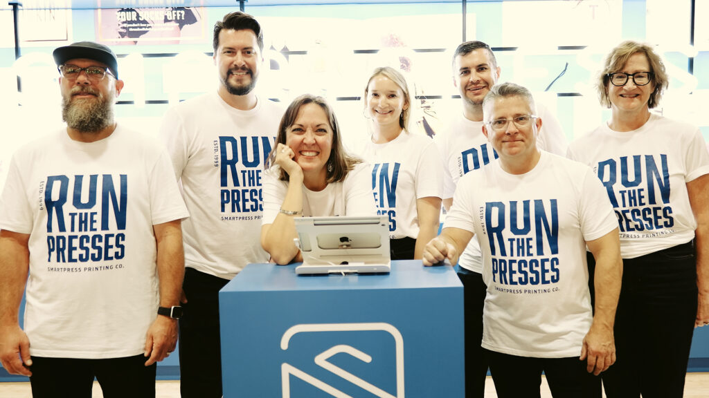 Smartpress representatives smiling in front of the Smartpress booth.