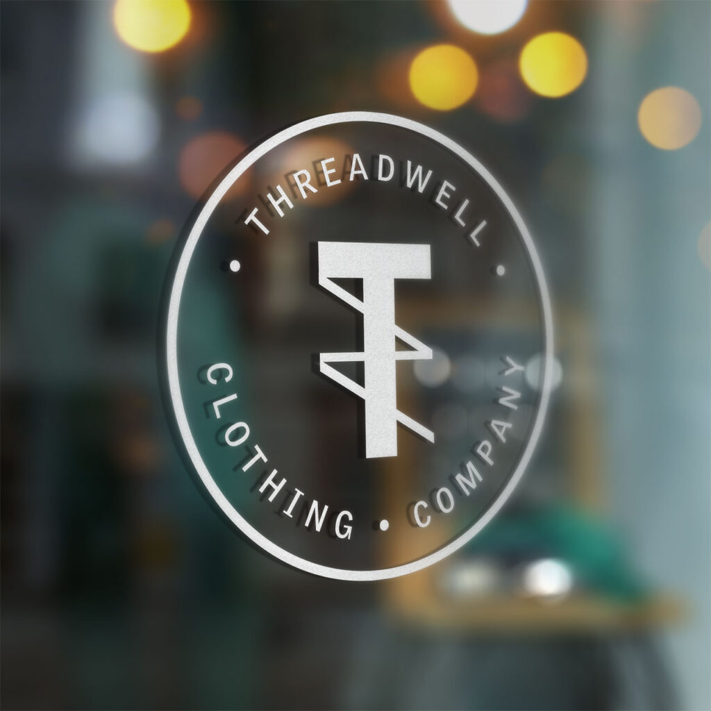 A custom static window cling printed with Threadwell Clothing Company in white.