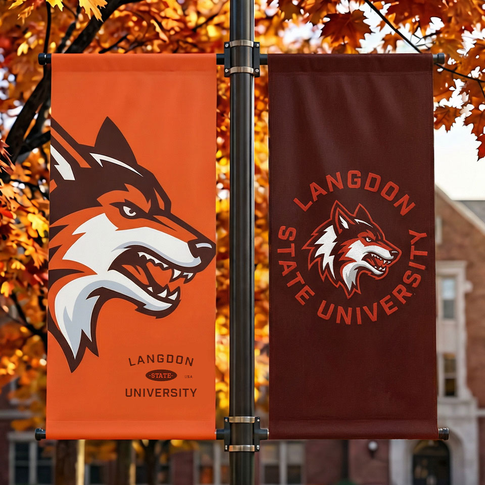 Two handing banners on a light pole printed with Langdon University branding in orange and maroon.