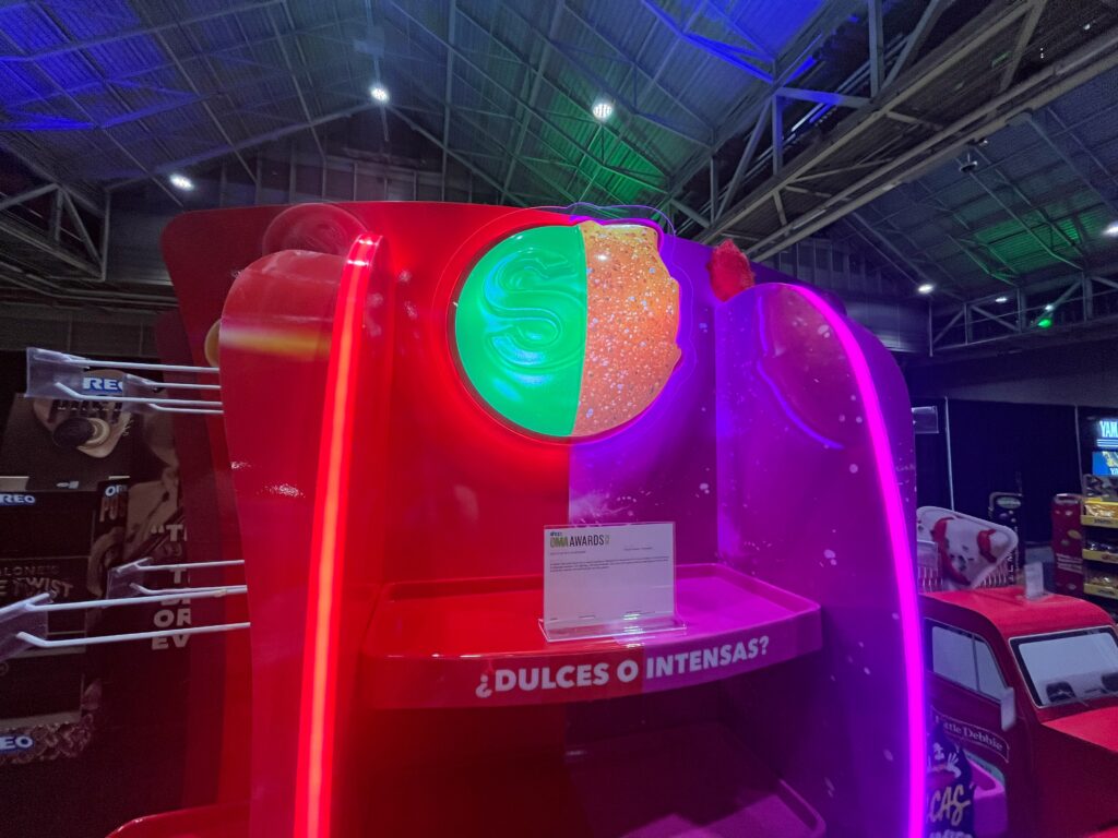 A Skittles retail display featuring a 50/50 vertical split with dynamic LED lighting and a 3D header showcasing two flavor profiles.