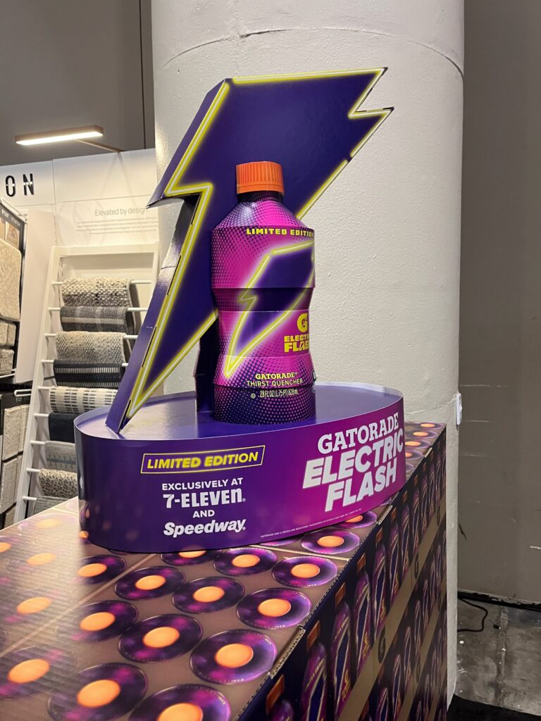 A vibrant Gatorade pallet topper display using bright neon inks and sharp vertical color-blocking simulating a lightning blast.
