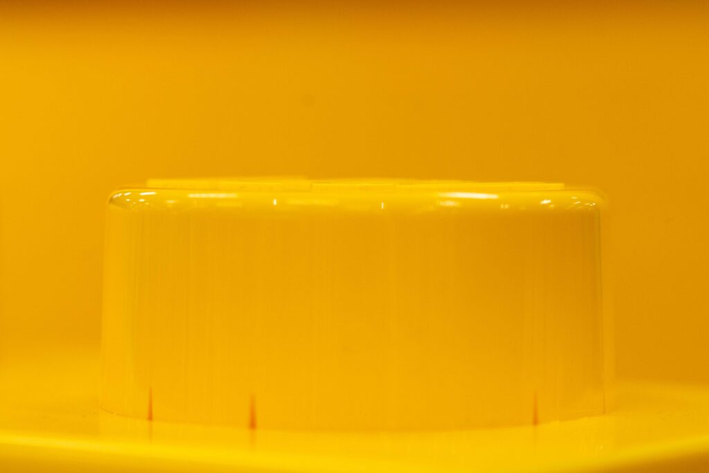 Shot of a single giant yellow LEGO brick stud atop a display pedestal.