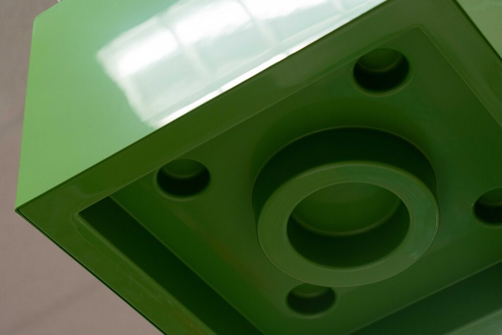 Extreme close-up of a large green plastic LEGO brick fixture hanging overhead as part of the Target store display.