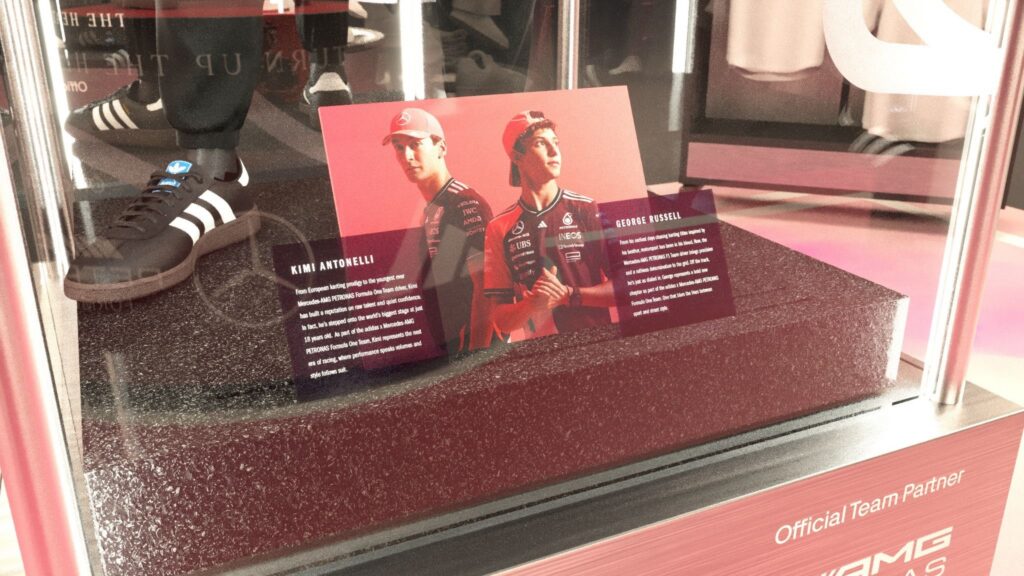 Close-up of a glass display case featuring Mercedes-AMG PETRONAS F1 drivers Kimi Antonelli and George Russell alongside branded footwear.