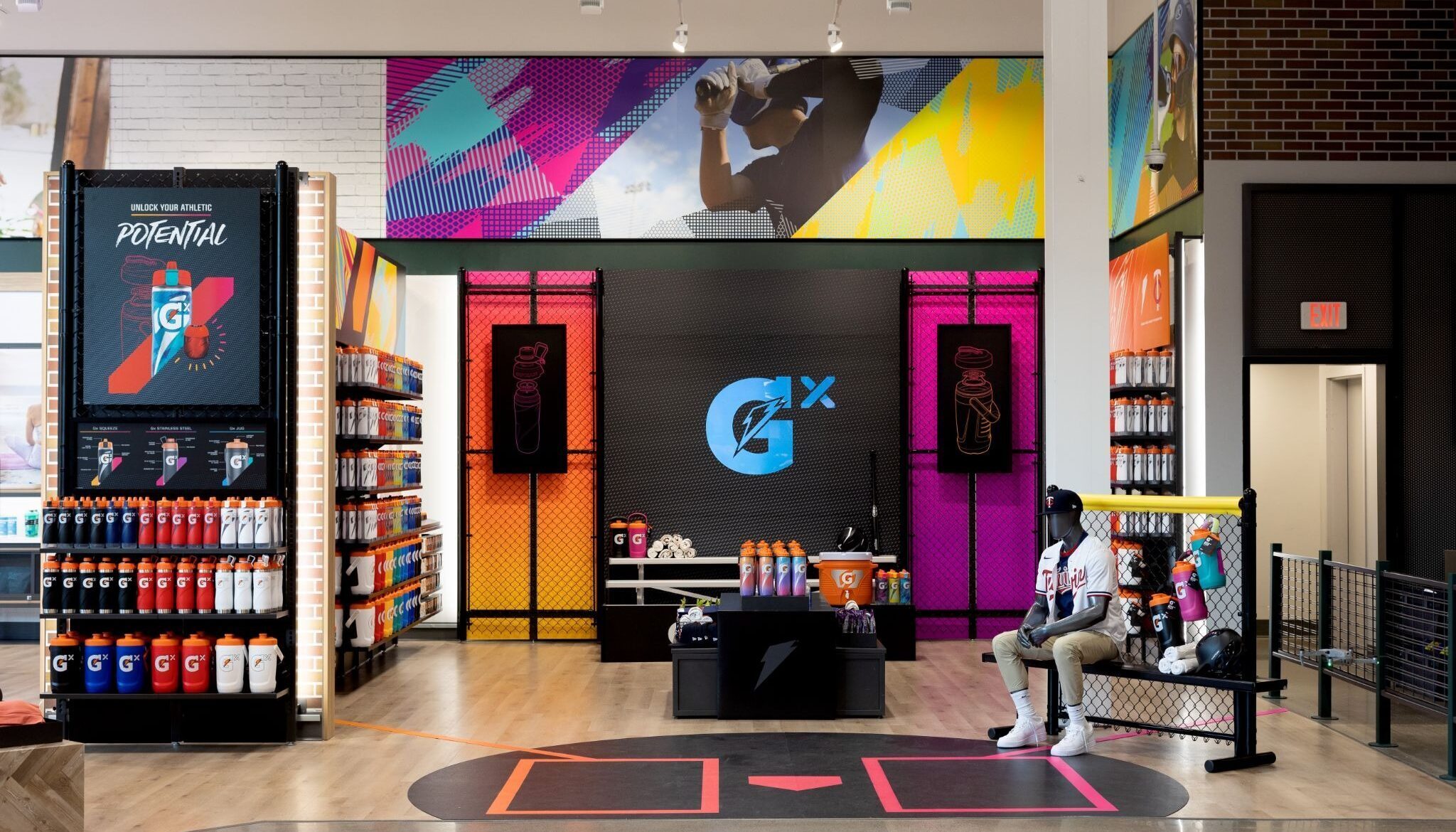 Athletic Gatorade retail setup with "Unlock Your Potential" messaging, stadium bench seating, and home-plate floor graphics.