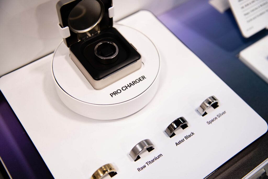 Close-up detail shot of the Ultrahuman smart ring resting on its custom illuminated charging pedestal.