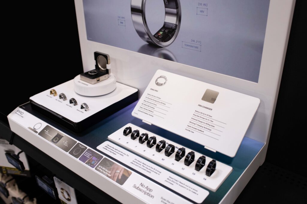 Angled view of an interactive Ultrahuman retail display showcasing smart ring color finishes, sizing kits, and product specifications.